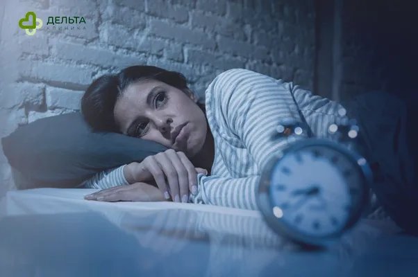 Девушка лежит в постели с будильником на фоне